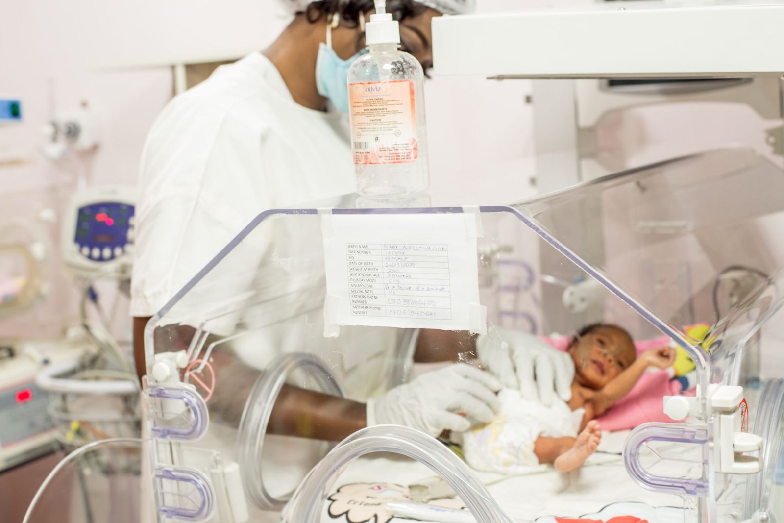 A nurse caring for a newborn in an incubator in the neonatal unit